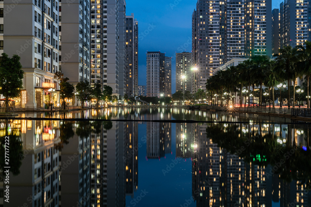 Twilight scene of modern city with buildings and reflection on lake in Hanoi, Vietnam Twilight scene of modern city with buildings and reflection on lake in Hanoi, Vietnam
