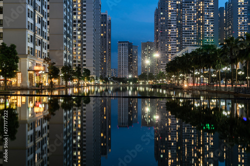 Twilight scene of modern city with buildings and reflection on lake in Hanoi, Vietnam © Hanoi Photography