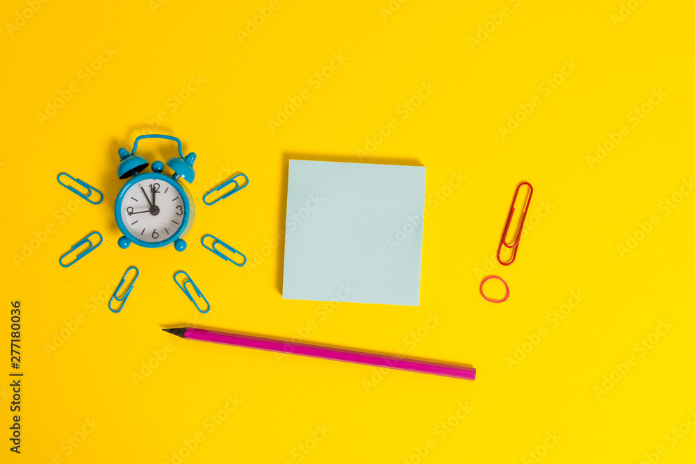 Alarm clock wakeup clips rubber band pencil notepad colored background Alarm clock wakeup clips rubber band pencil notepad colored background