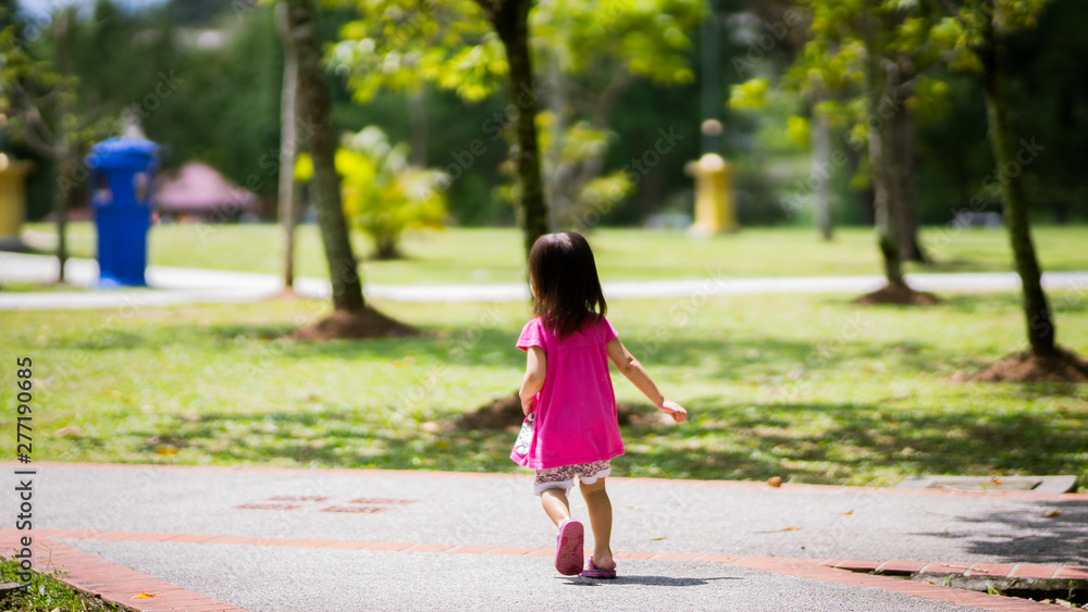 Asian toddler girl running in the park at the spring or summer day. Asian toddler girl running in the park at the spring or summer day.