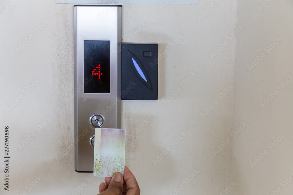 securing lift or elevator access control. elevator access control, Hand  holding a key card to unlock elevator floor before up or down. Stock Photo  | Adobe Stock