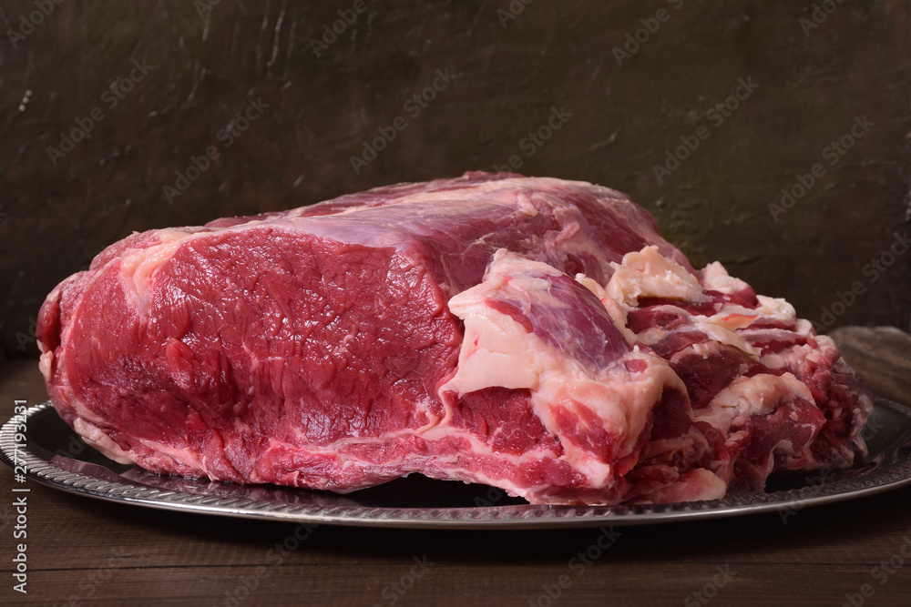 A big piece of raw meat for a steak in a dish