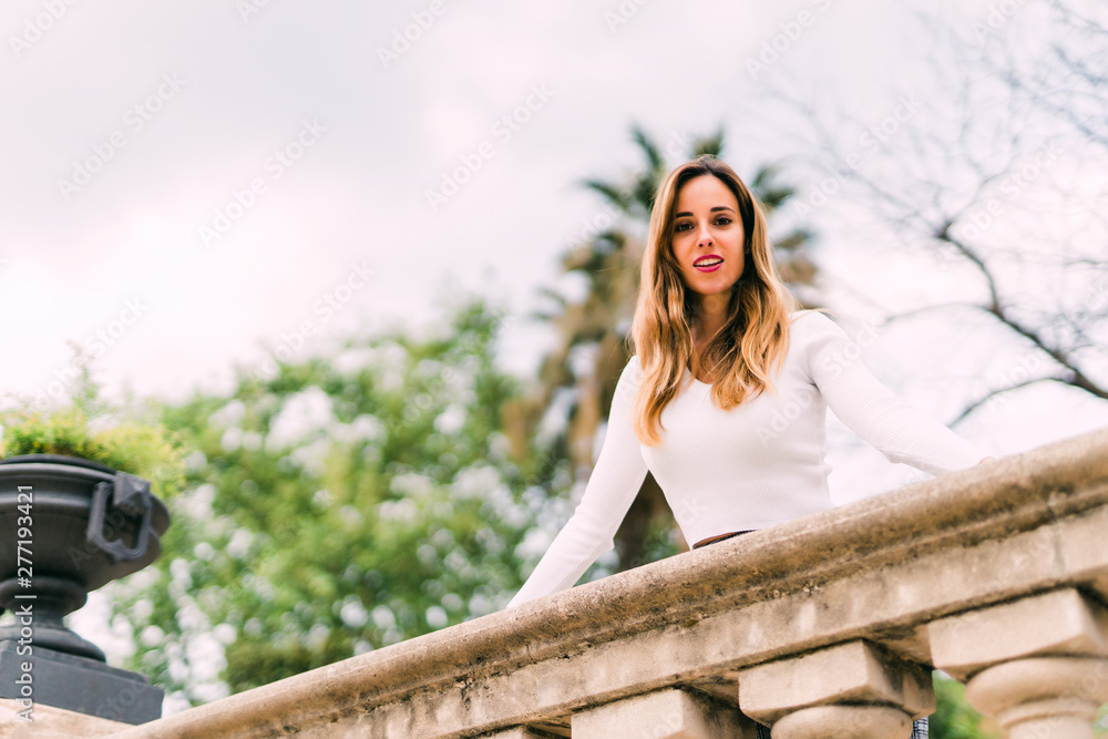 Naklejka premium Young pretty woman in sunny summer park