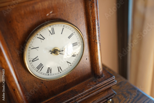 Old table clock of the wooden frame of the room