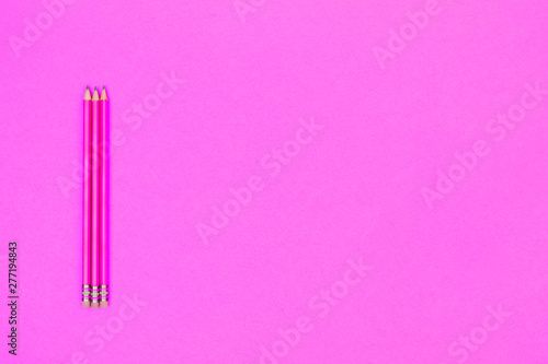 Pencils and apple on a neon pink background. Back to school concept. Horizontal
