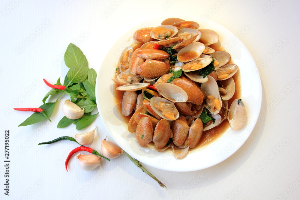 Stir fried clam with chili paste and thai basil leaf in white dish,On the white background, This is thai food cuisine.