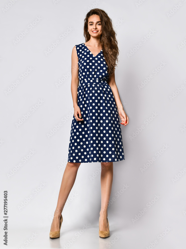 Woman in polka dot Dress in Fashion Store - Portrait of girl in a clothes shop in a midi summer dress Woman in polka dot Dress in Fashion Store - Portrait of girl in a clothes shop in a midi summer dress