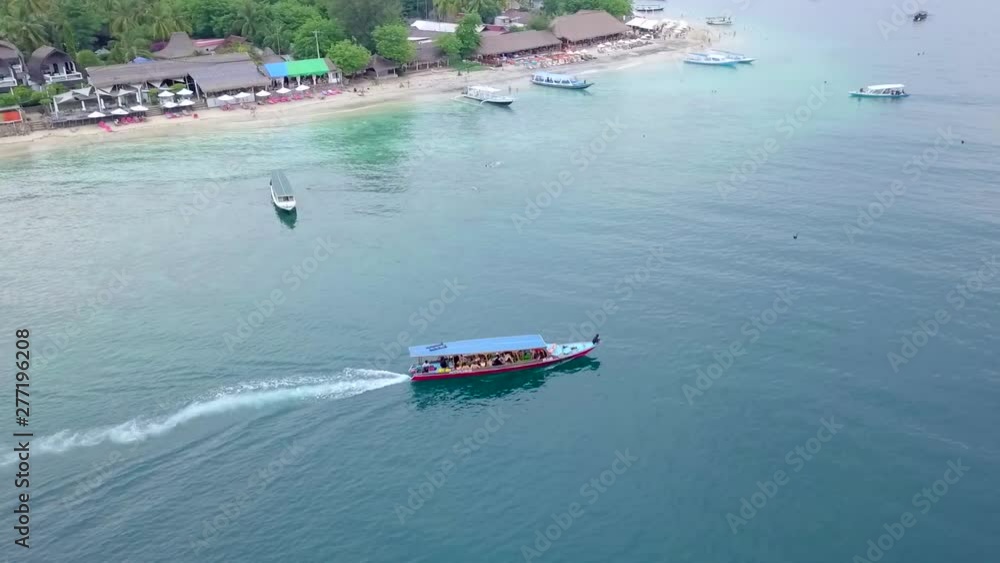 Gili Air, Indonesia, 2019: shooting from the drone of a passenger boat off the coast of the island. It's a nasty day. Tourists on a transport boat sailing to the next island. Gili Air, Indonesia, 2019: shooting from the drone of a passenger boat off the coast of the island. It's a nasty day. Tourists on a transport boat sailing to the next island.