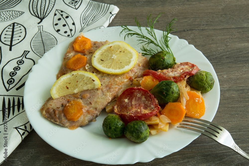 Baked white fish with lemon, cabbage, carrots, tomatoes, potatoes