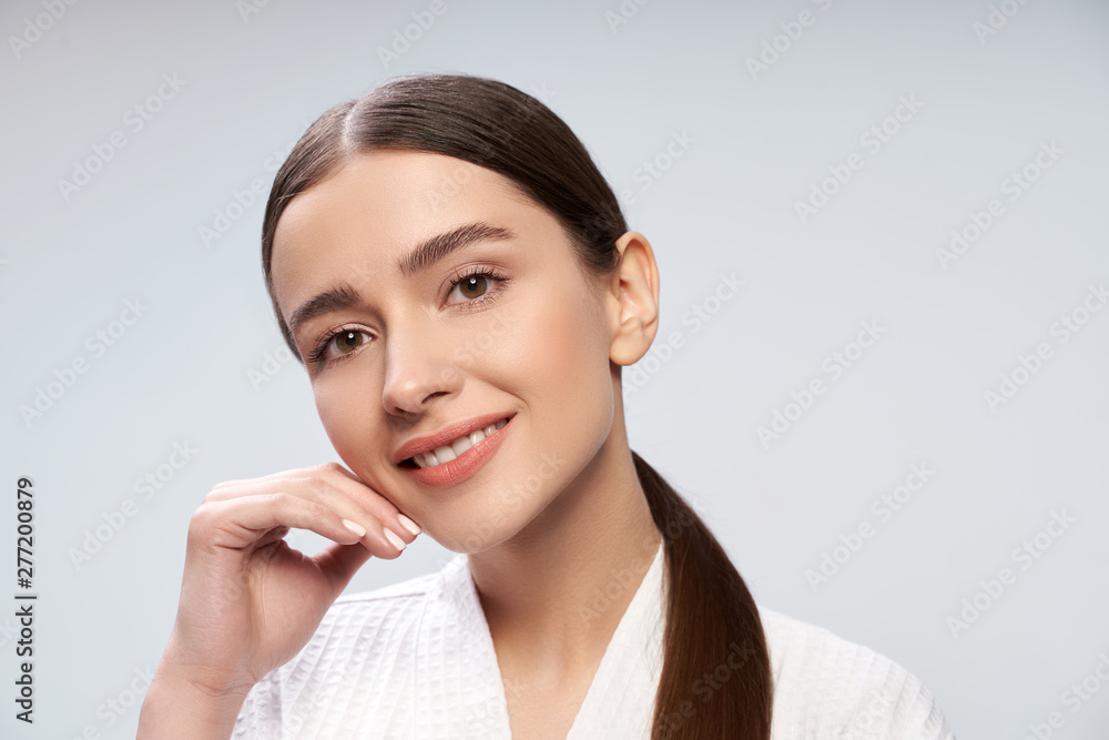 Pretty girl with perfect skin standing against light blue background Pretty girl with perfect skin standing against light blue background