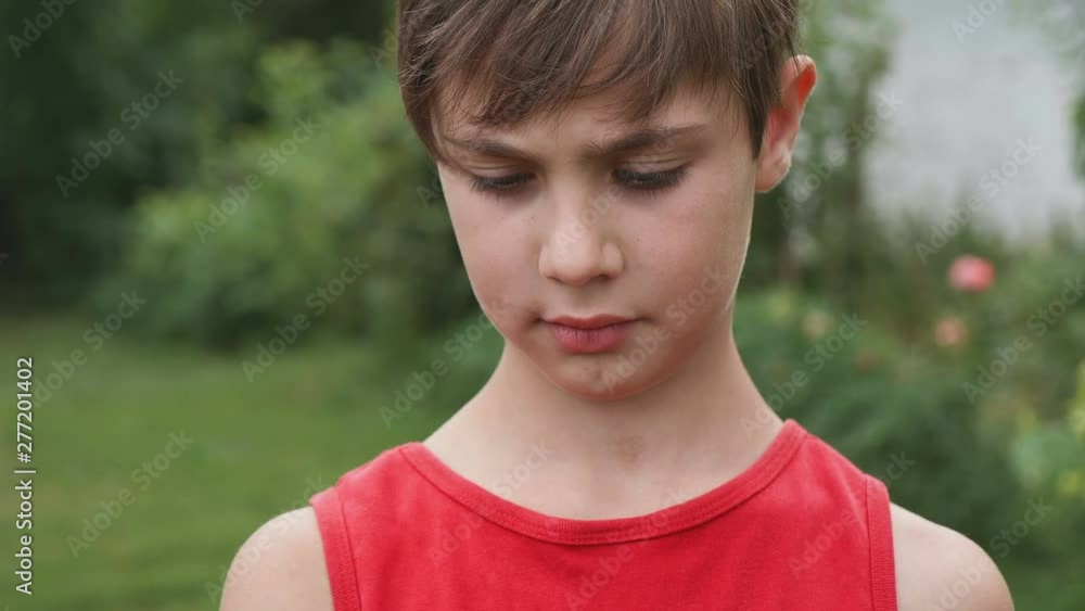 portrait of a boy 10 years old using smartphone on a background of green garden in spring or summer. portrait of a boy 10 years old using smartphone on a background of green garden in spring or summer.