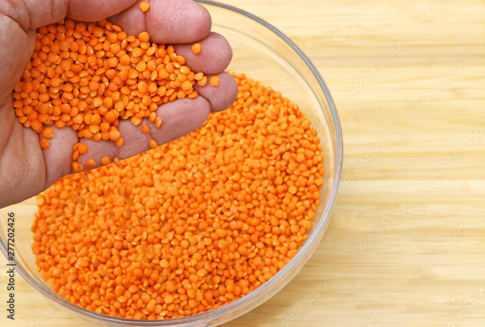 hand letting lentils trickle into a bowl hand letting lentils trickle into a bowl