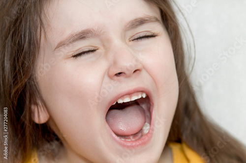 Little agressive angry girl screaming on white background