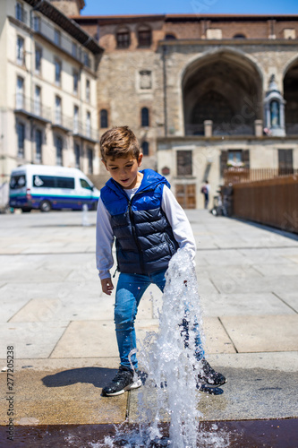 Little child playing wuit a water jets in Vitoria photo