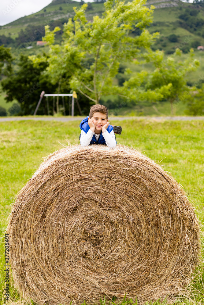 Cute boy on top of a straw bale Cute boy on top of a straw bale