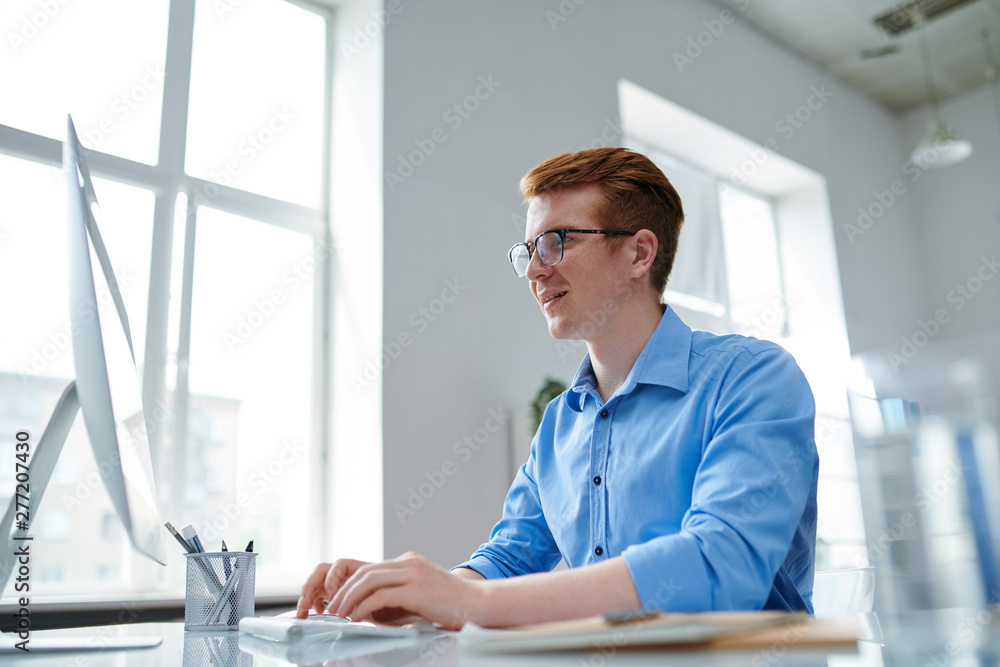 Fototapeta premium Happy guy in formalwear looking at computer screen