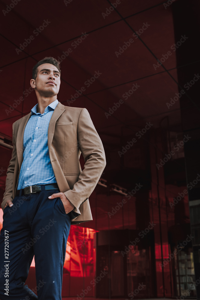 Confident young businessman near modern office building