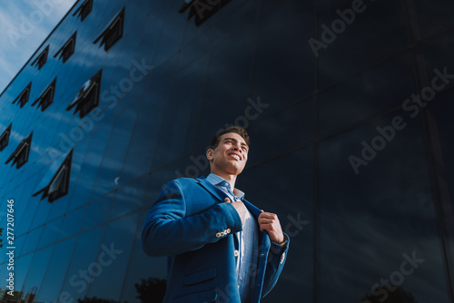 Cheerful executive near modern business center outdoors