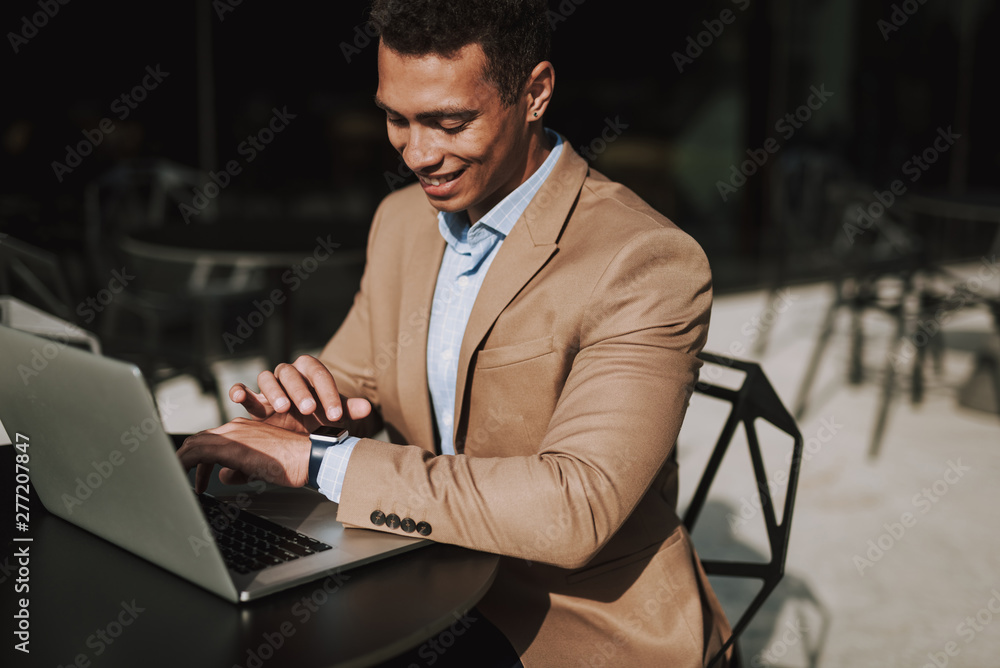 Merry elegant man is using gadgets in cafe Merry elegant man is using gadgets in cafe