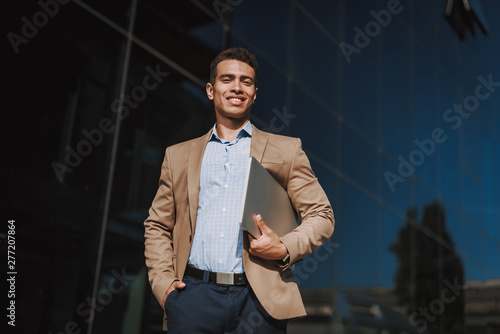 Naklejka Cheerful man is going to work with notebook