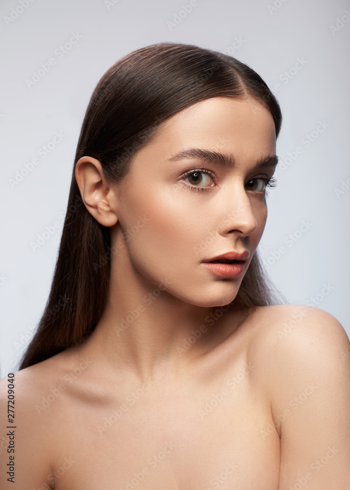 Cheerful naked lady standing against light gray background Cheerful naked lady standing against light gray background