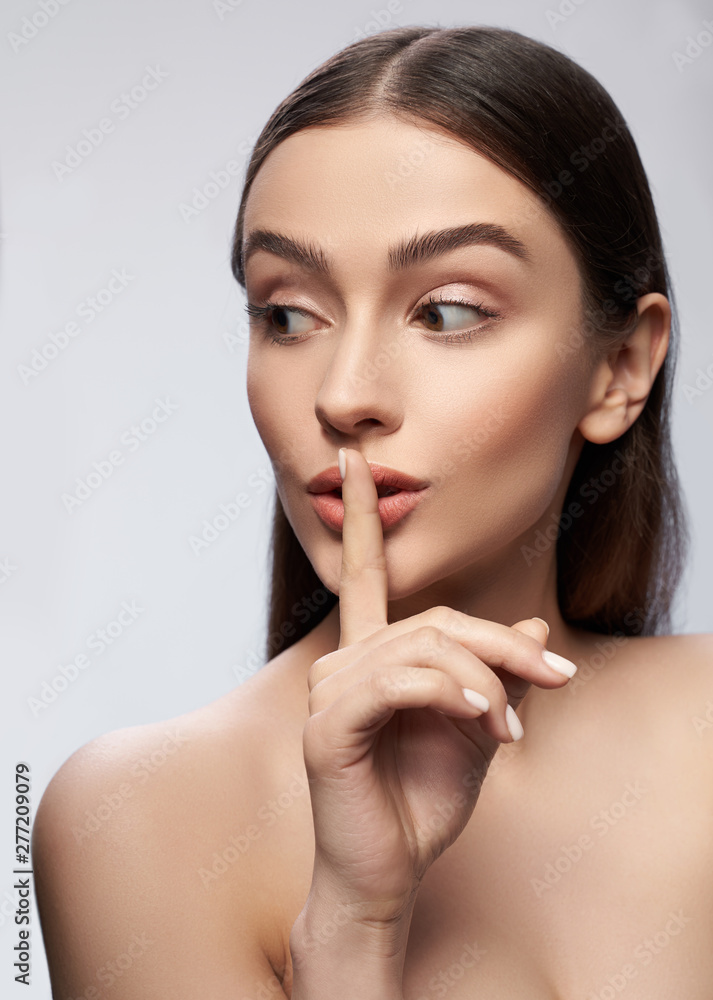 Calm young lady is posing against light gray background Calm young lady is posing against light gray background