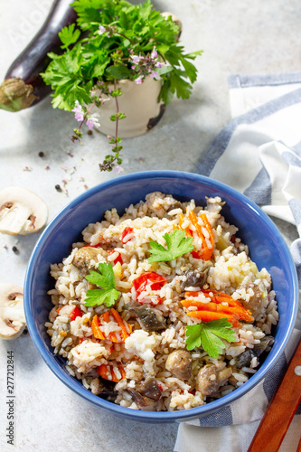 Diet menu. Healthy food. Vegetarian vegetable mushrooms pilaf. Rice with eggplant and mushrooms on stone table.