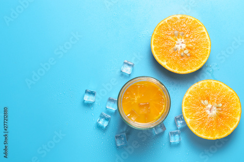 Glass of orange juice with sliced orange fruits with ice cubes on blue background  flat design