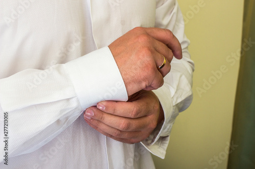 man fastens the buttons on the cuffs.