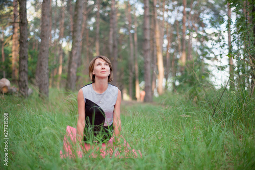 Woman practicing yoga alone in the forest outdoor