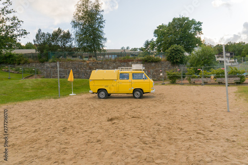 70s yellow buss parked on sand 