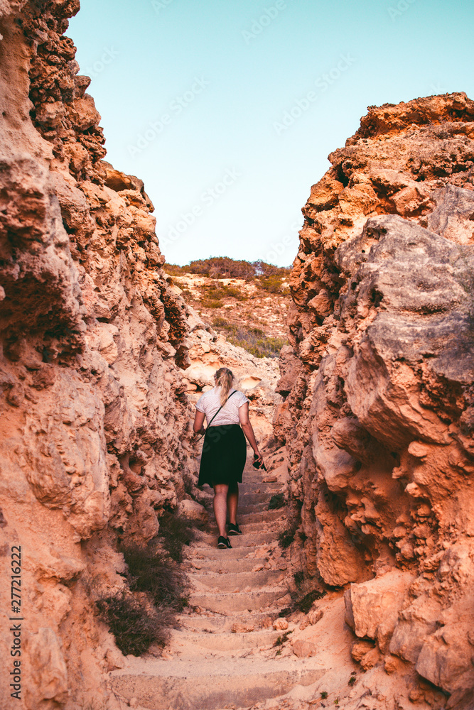 A young active girl exploring the wild coast nature of Mallorca during summer vacation with colorful sunset light. Mallorca Spain Balearics Islands A young active girl exploring the wild coast nature of Mallorca during summer vacation with colorful sunset light. Mallorca Spain Balearics Islands