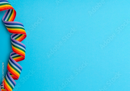 spiral rainbow ribbon on blue background top view copy space