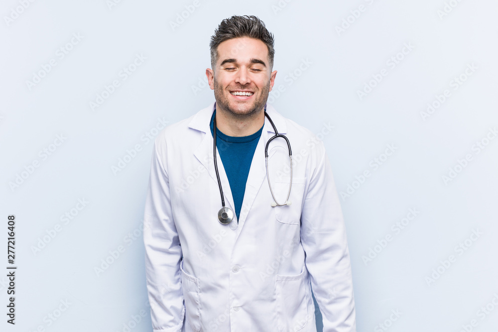 Young handsome doctor man laughs and closes eyes, feels relaxed and happy. Young handsome doctor man laughs and closes eyes, feels relaxed and happy.