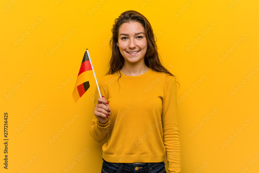 Young european woman holding a germany flag happy, smiling and cheerful. Young european woman holding a germany flag happy, smiling and cheerful.