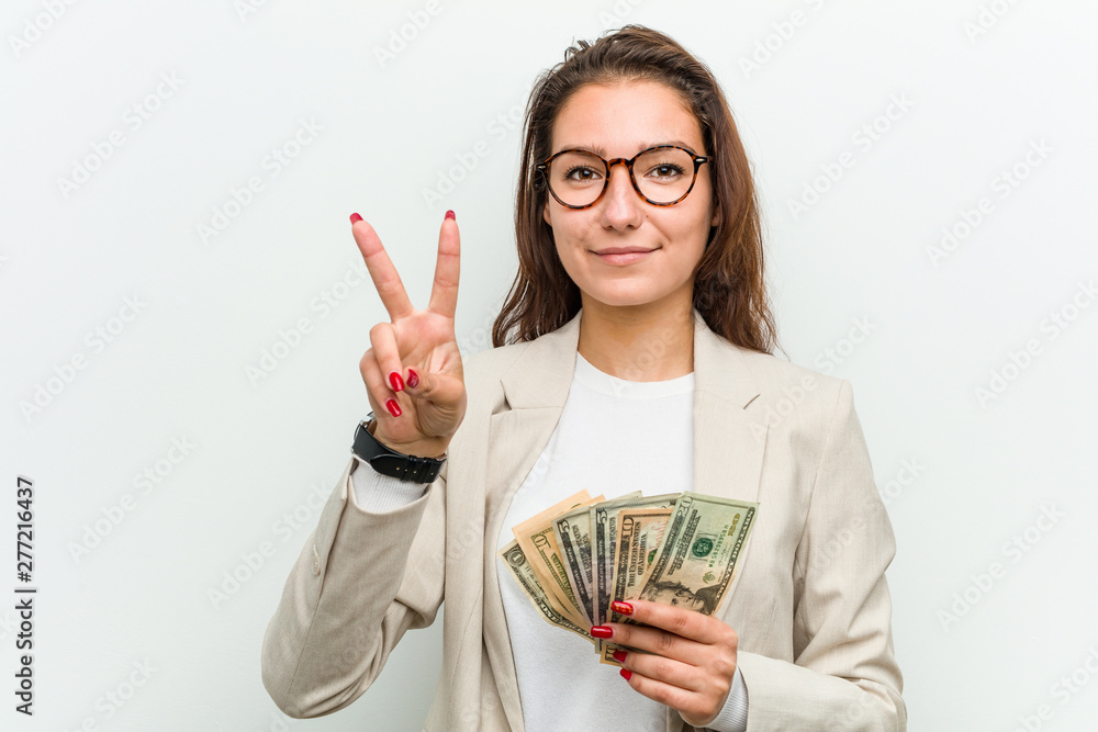 Young european business woman holding dollar banknotes showing number two with fingers. Young european business woman holding dollar banknotes showing number two with fingers.