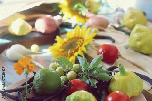 Bright fresh vegetables, fruits and flowers on a wooden table, healthy food, the season of summer, autumn