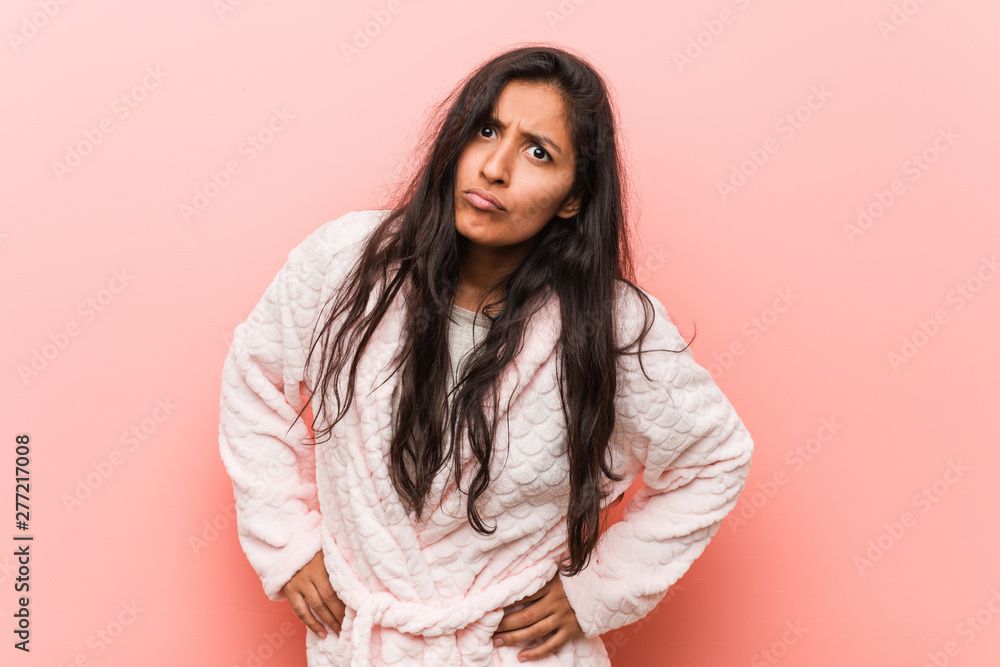 Young indian woman wearing pajama scolding someone very angry.