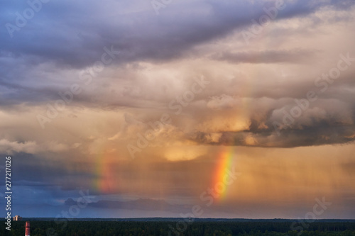 Rainbow over the forest against a contrasting sky. Beautiful scenery © Vitalii Makarov