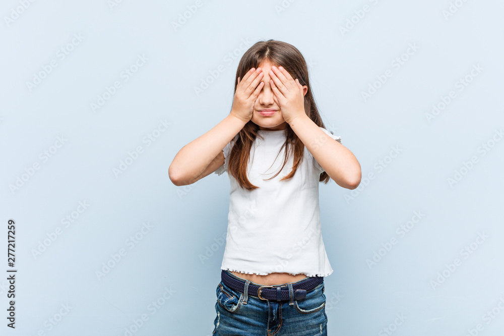 Cute girl covers eyes with hands, smiles broadly waiting for a surprise. Cute girl covers eyes with hands, smiles broadly waiting for a surprise.