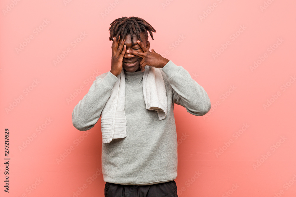 Young fitness african black man blink through fingers frightened and nervous. Young fitness african black man blink through fingers frightened and nervous.
