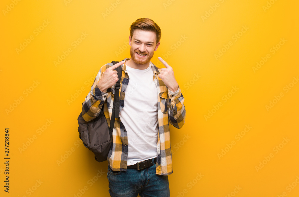 Young redhead student man smiles, pointing mouth Young redhead student man smiles, pointing mouth
