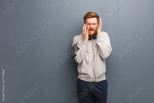 Young fitness redhead man desperate and sad