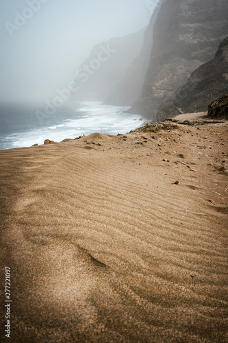 Santo Antao, Cape Verde - Cruzinha da Garca. Mountain moody coastline and Atlantic ocean waves. Sandy dune in foreground photo