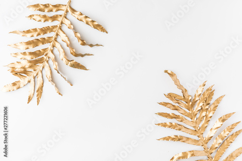 Gold tropical monstera leaves on white background. Flat lay, top view. Tropic...