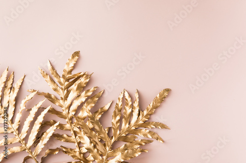 Creative layout with golden tropical leaves on pink background. Minimal summe...