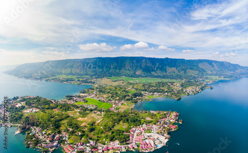 Aerial: lake Toba and Samosir Island view from above Sumatra Indonesia. Huge volcanic caldera covered by water, traditional Batak villages, green rice paddies, equatorial forest. photo