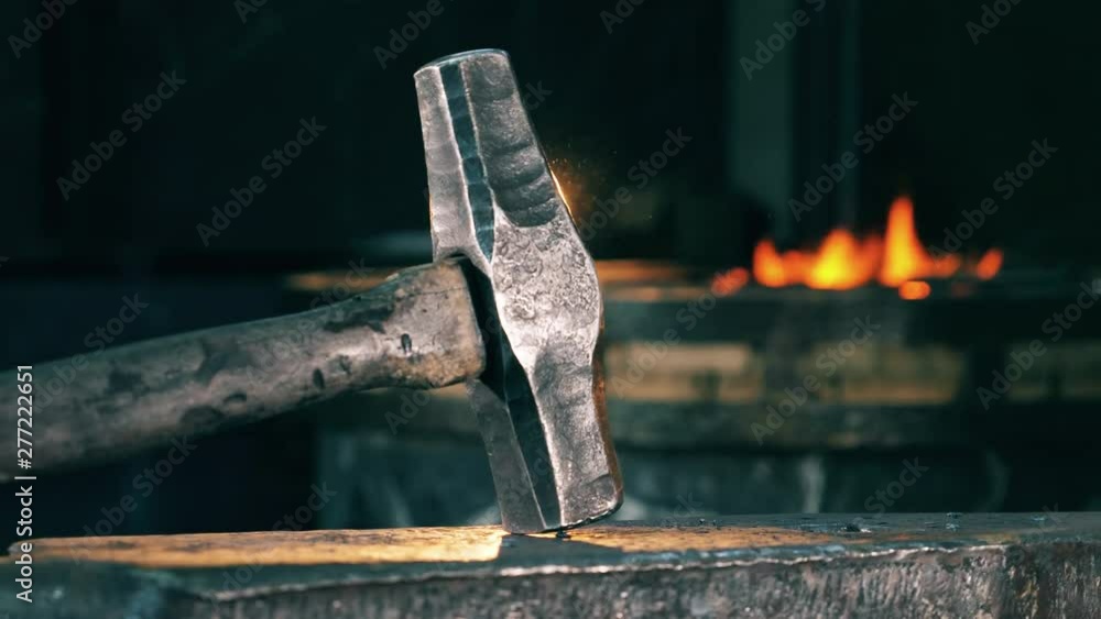 A hammer is lying on the anvil's surface A hammer is lying on the anvil's surface