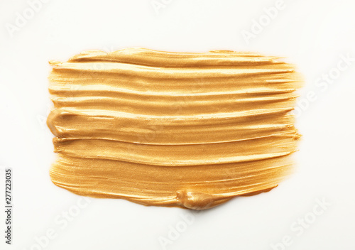 Stroke of gold paint isolated on white, top view
