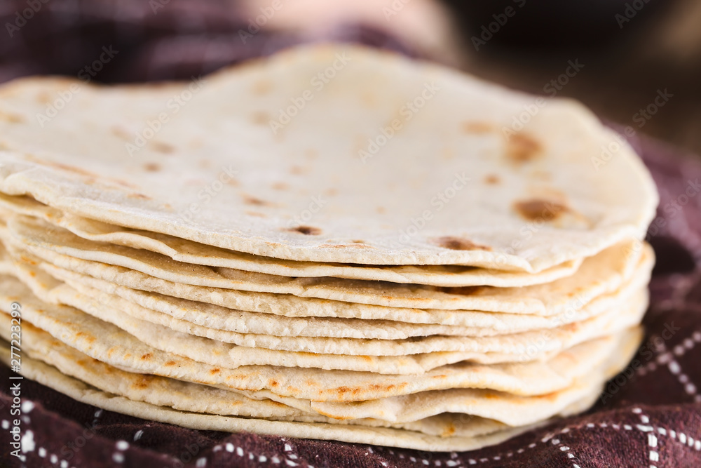 Fresh homemade flour tortillas on kitchen towel (Selective Focus, Focus on the front of the tortillas) Fresh homemade flour tortillas on kitchen towel (Selective Focus, Focus on the front of the tortillas)